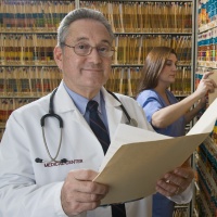 This is a picture of a doctor smiling holding a file.