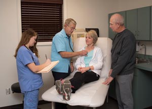 This is a picture of a doctor listening to a elderly lady&apos;s  breath sounds