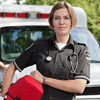 This is a picture of a Paramedic standing in front of a ambulance.